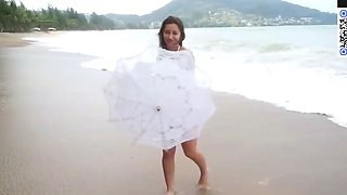 A brown-haired chick in a white bathing suit top gives a
